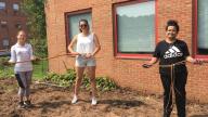 A group of people holding a long root of Japaneese Knotweed