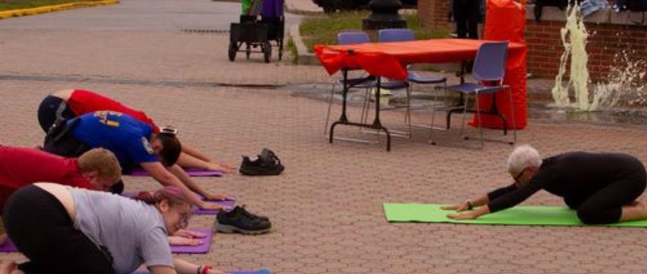 A group of people stretching on mats outside​