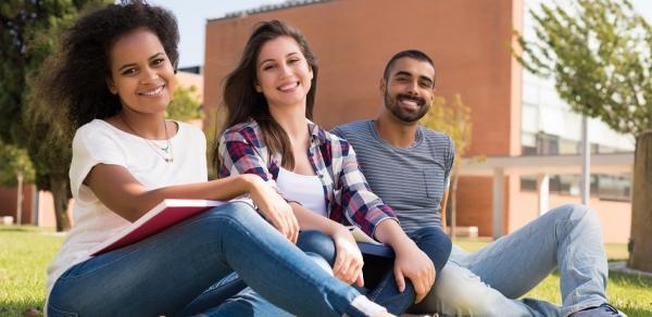 group of students sitting on ground on campus