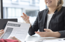 Two people reviewing a resume at a desk